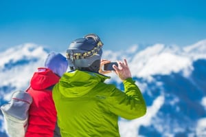 man taking a photo on top of a mountain