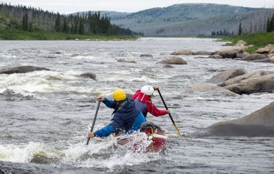 Expedition Ikivuq team members paddling a canoe in rough water