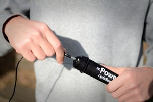 Man pluging a USB cable into the LightSaver Portable Solar Charger