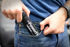Man putting a LightSaver Portable Solar charger into his jeans pocket