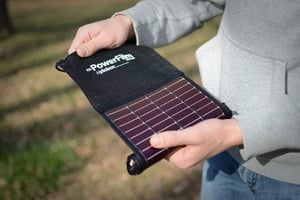 Man unrolling a LightSaver Portable Solar Charger