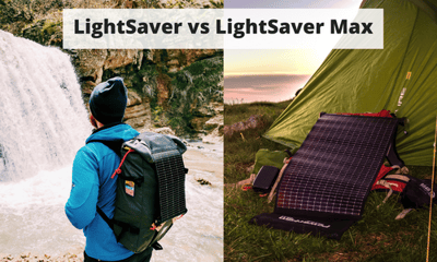 Man with a LightSaver Portable Solar Charger on his backpack staring a waterfall and a unrolled LightSaver Max next to a tent