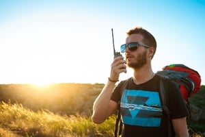Young man talking on a walkie talkie radio enjoying canyon view