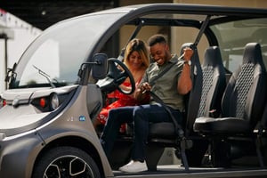 Couple in a GEM car buckling up and getting ready to drive.