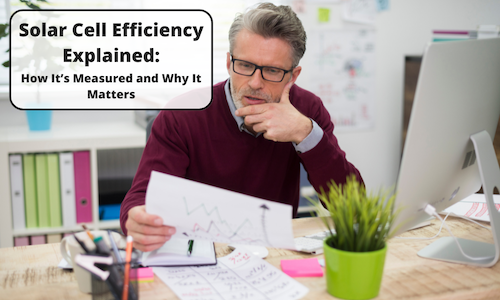 A middle-aged man with glasses and a beard sits at a desk, analyzing a printed chart with graphs. The workspace is filled with office supplies, a computer, and sticky notes. A text overlay in a black-bordered white box reads: 'Solar Cell Efficiency Explained: How It’s Measured and Why It Matters.'