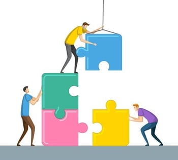 Illustration of three people assembling oversized puzzle pieces. One person stands on stacked puzzle pieces, guiding a suspended blue piece into place, while the other two support the structure from below. Concept represents teamwork and collaboration.