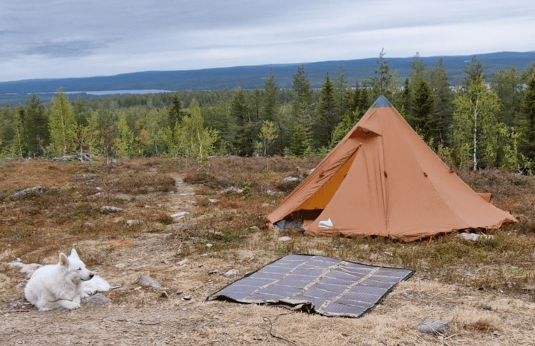 Portable shelter protecting an amateur radio operator and station equipment during an outdoor Field Day deployment.
